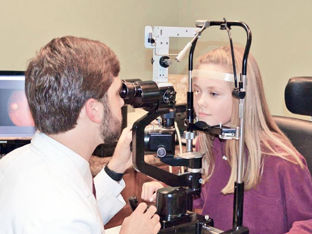 A happy child getting an eye exam in Okotoks, Alberta with Fantastic Glasses